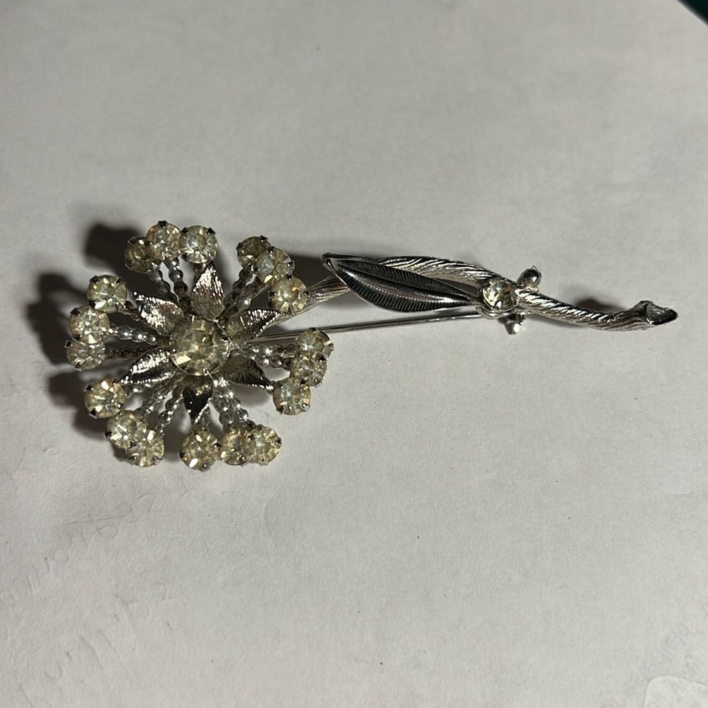 Sparkly silver flower brooch.